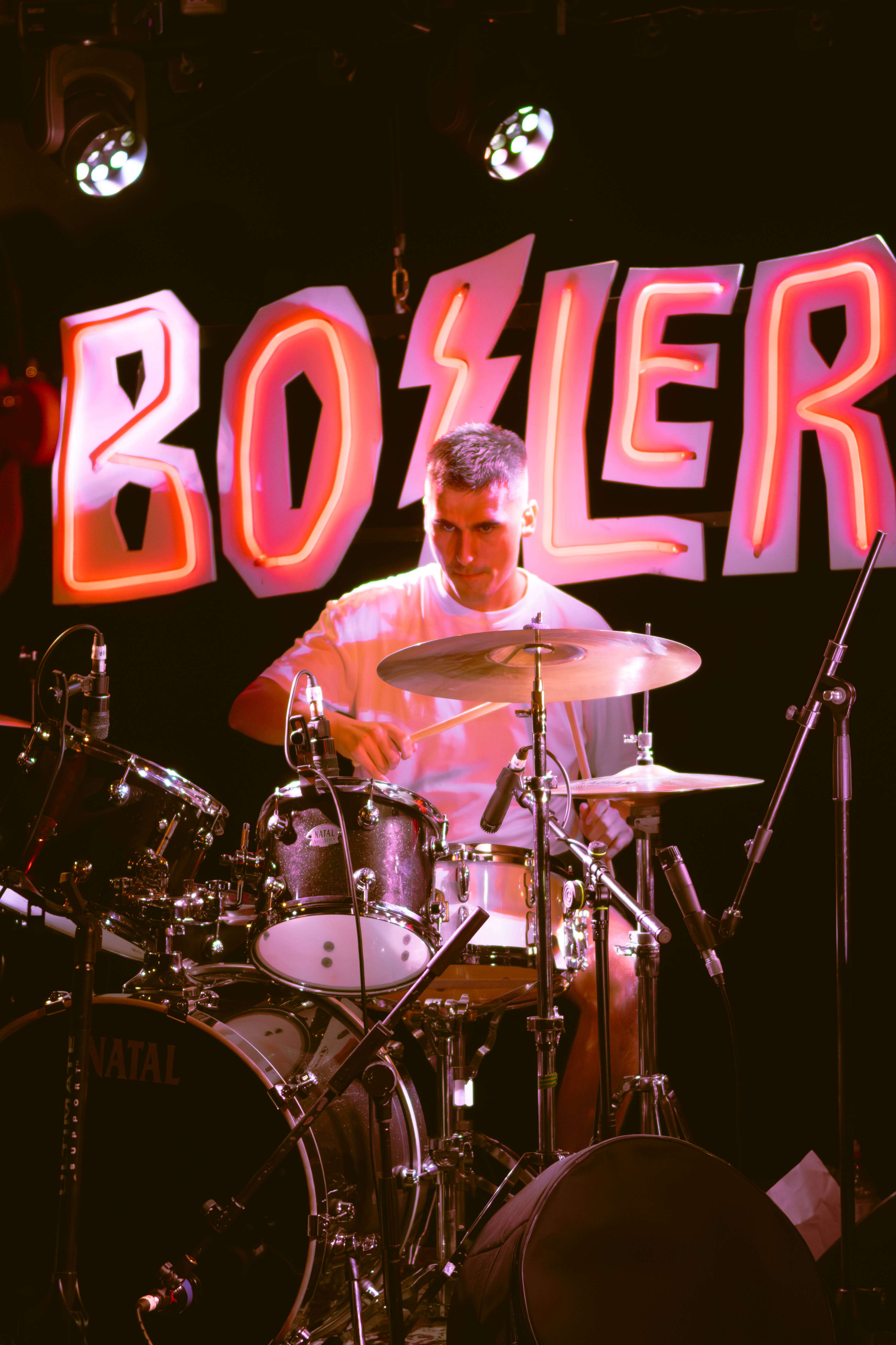 The Passengers indie rock band drummer performing live with professional stage lighting UK