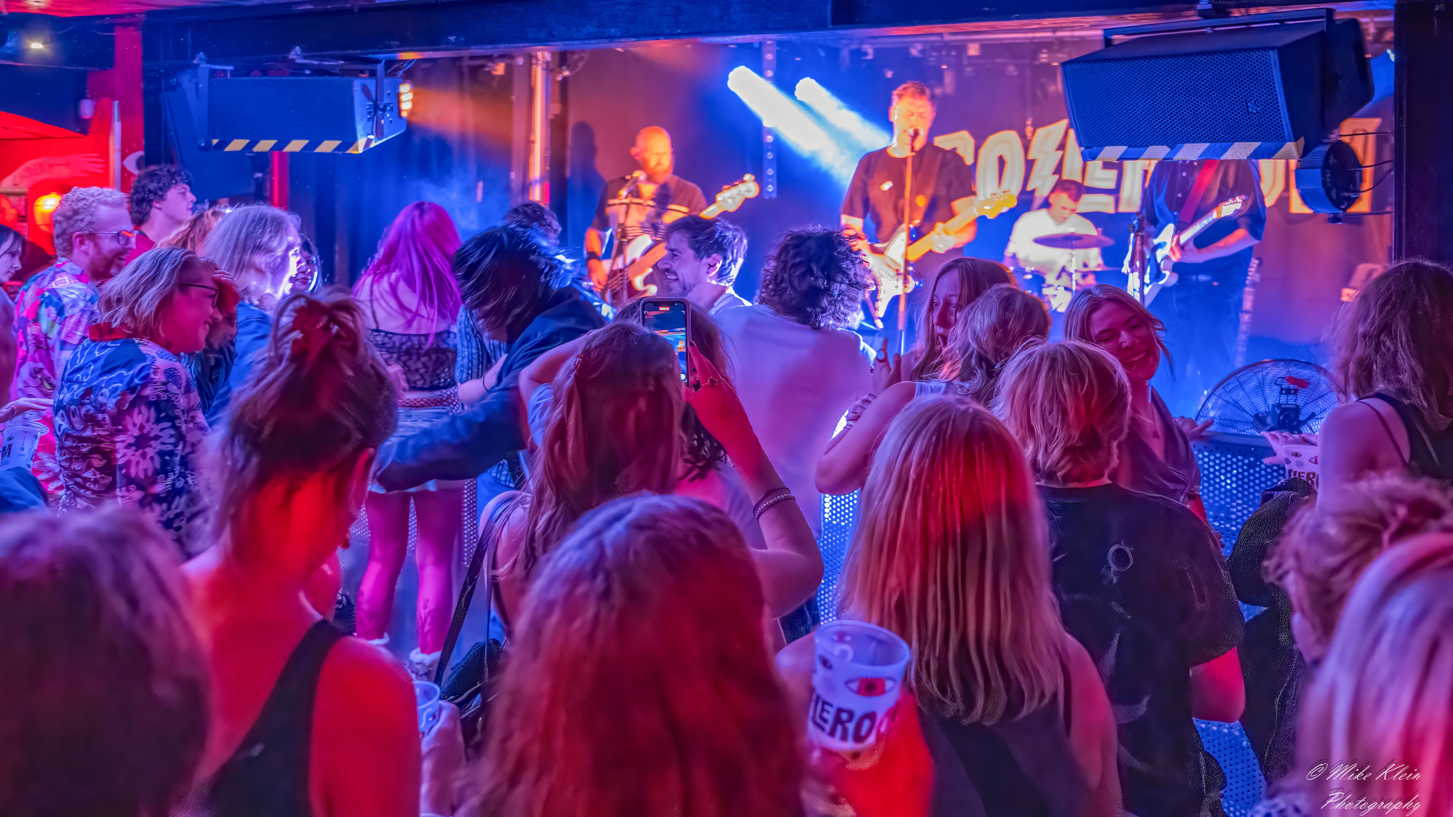 Crowd perspective The Passengers wedding band performance vibrant stage lighting Surrey