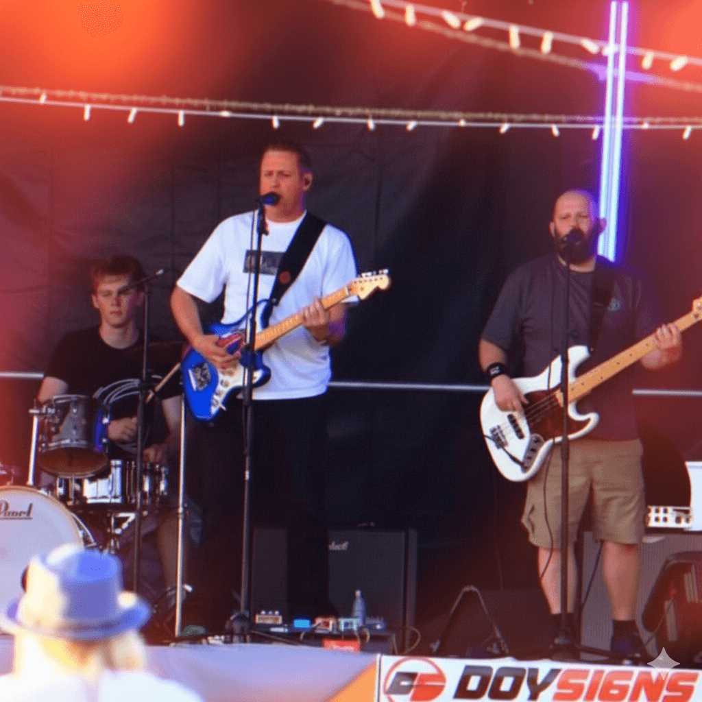 The Passengers performing on outdoor festival stage with red lighting